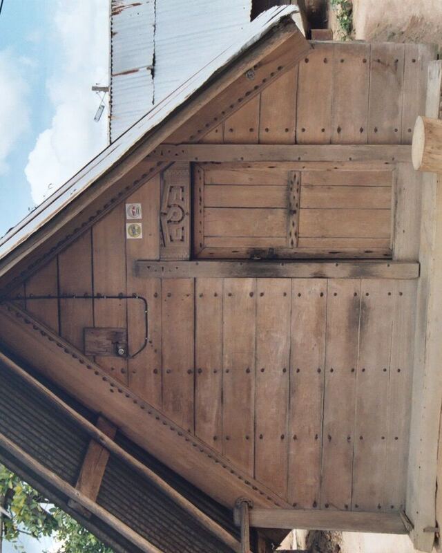 Houten topgevel van een traditioneel huis met dichte houten deuren en gesneden randen.